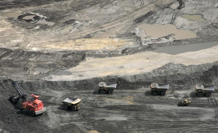 A convoy of 400 ton dump trucks carries the bitumen-laden sands