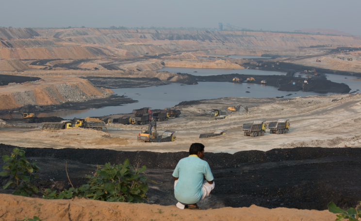A man stands on the edge of the PKEB minning site that was earlier his village land in Ghatbarra